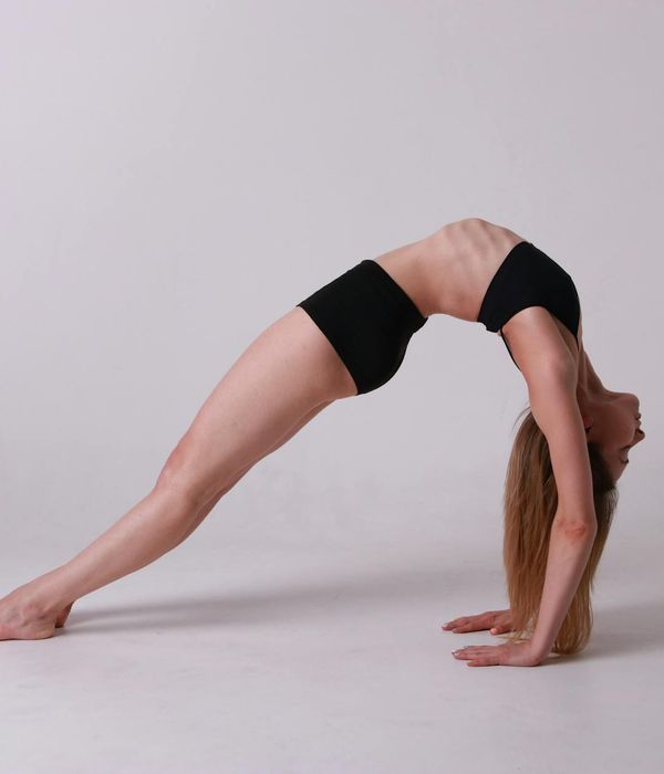 Woman practicing yoga pose for flexibility and balance in studio.